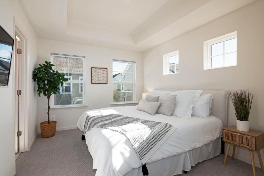 a white bedroom with a large bed and windows at New Intown Waterfront Townhome wPool & Location in Cambridge