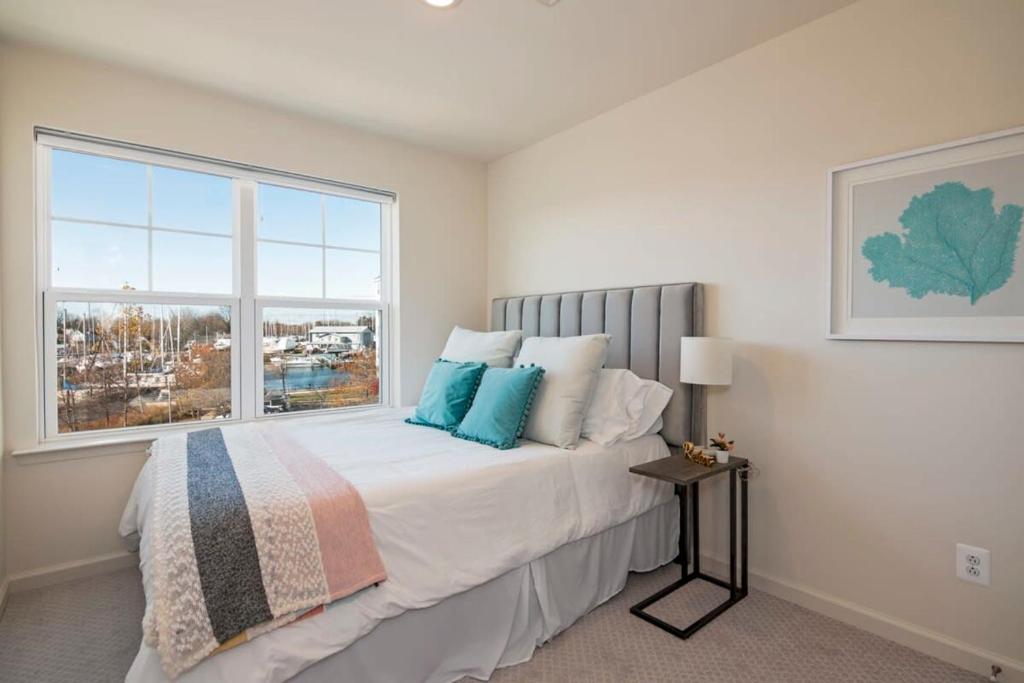 a bedroom with a large bed with a window at New Intown Waterfront Townhome wPool & Location in Cambridge