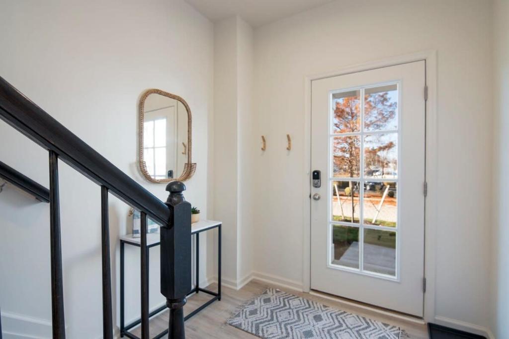a hallway with a staircase and a door with a mirror at New Intown Waterfront Townhome wPool & Location in Cambridge