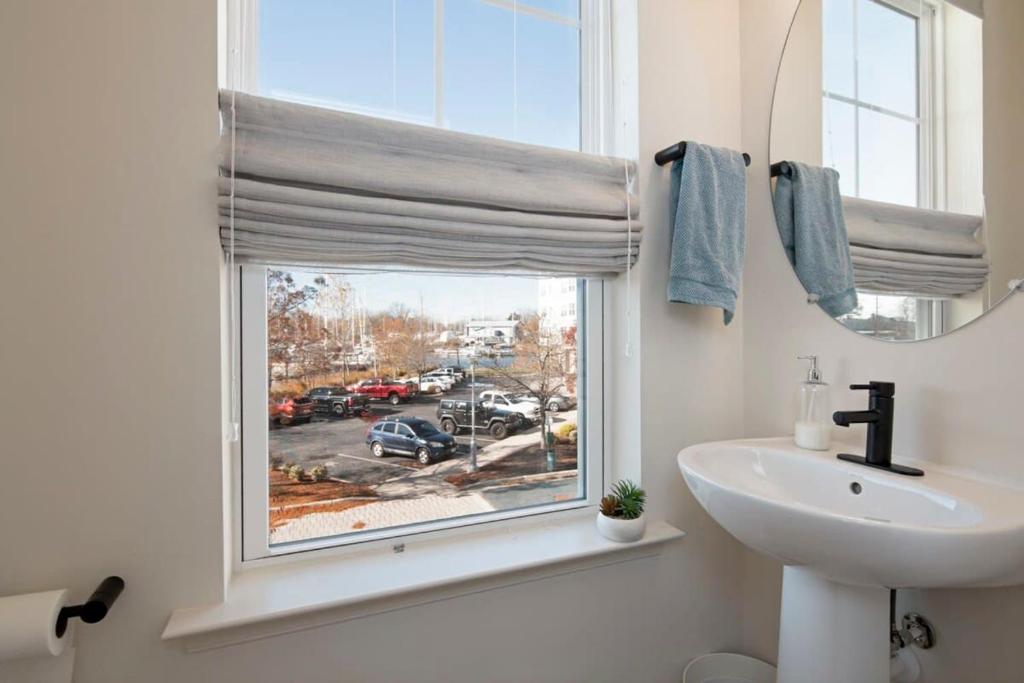 a bathroom with a sink and a window with a view of a parking lot at New Intown Waterfront Townhome wPool & Location in Cambridge