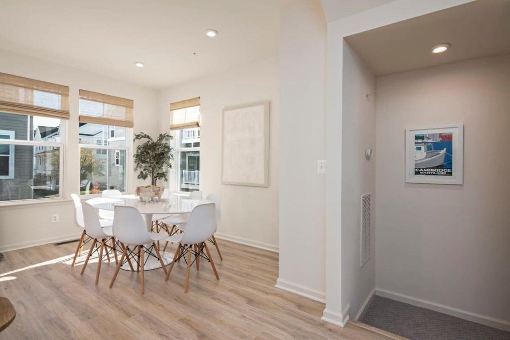 a dining room with a table and white chairs at New Intown Waterfront Townhome wPool & Location in Cambridge
