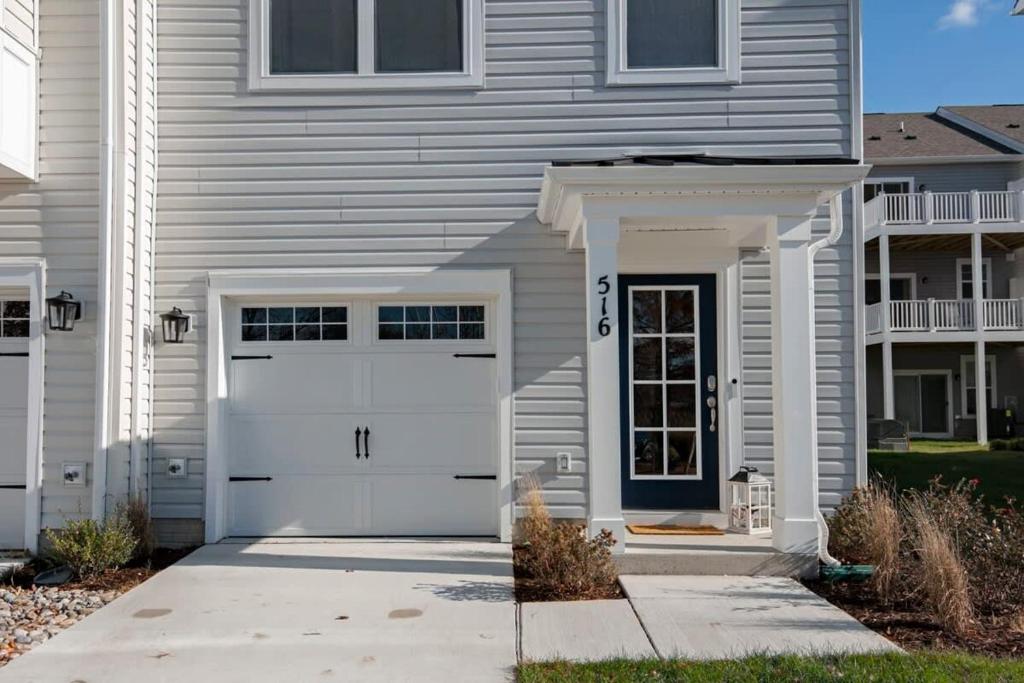 a white house with a white garage door at New Intown Waterfront Townhome wPool & Location in Cambridge