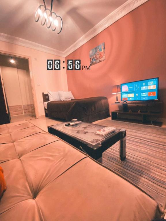 a living room with a couch and a flat screen tv at Layback apartment in 6 October city Cairo in 6th Of October