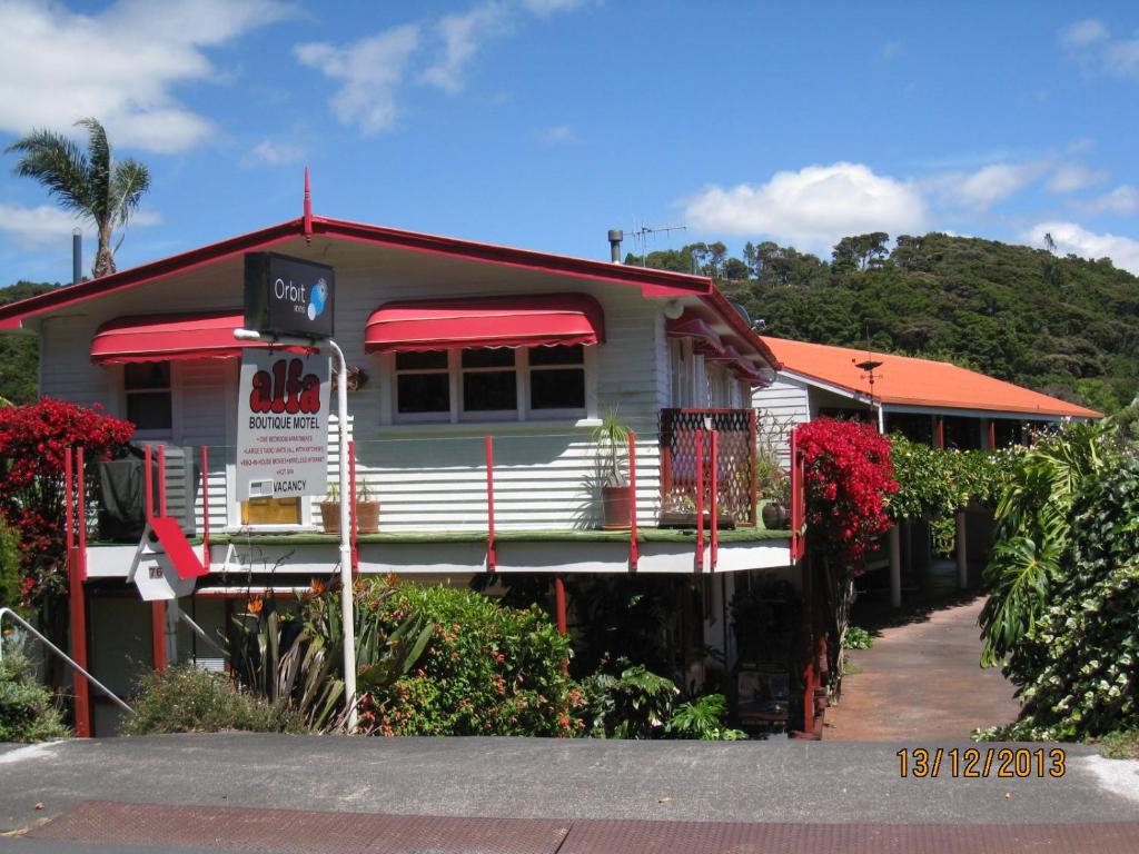 a house with red awnings on the side of it at Alfa Boutique Motel in Paihia