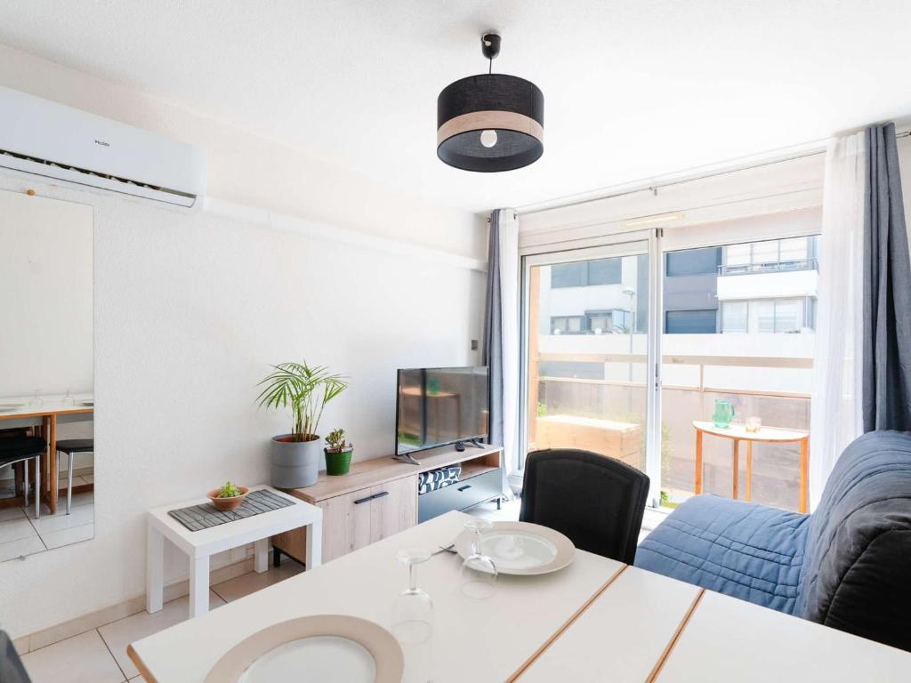 un salon avec un canapé, une table et une télévision dans l'établissement Studio cabine climatisé près de la plage avec parking à Narbonne - FR-1-409-274, à Narbonne