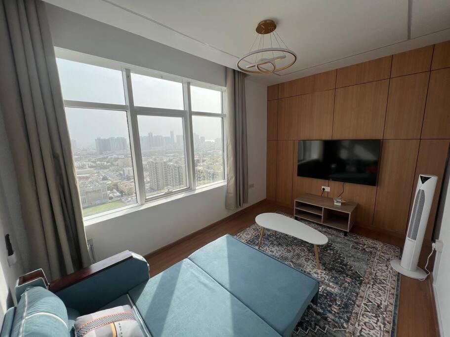 アジュマーンにあるElite Horizon Ajman Residenceのリビングルーム(ガラステーブル、大きな窓付)