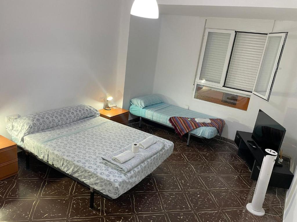 a bedroom with two beds and a tv in it at Habitación grande y comoda en piso particular y familiar in Valencia