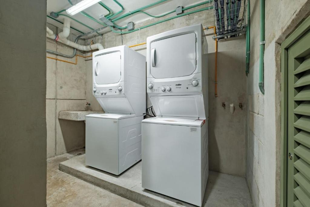 two washers and dryers in a laundry room at Casa Cibeles by Lumina in Mexico City