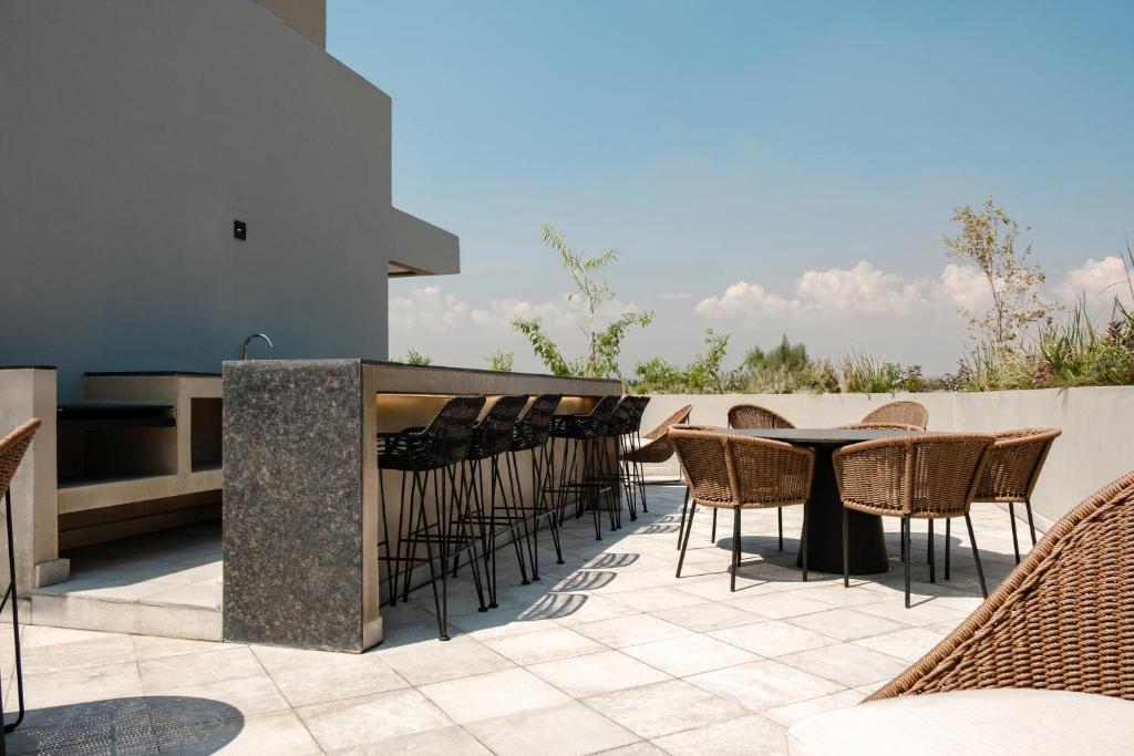a patio with a table and chairs and a bar at Casa Cibeles by Lumina in Mexico City