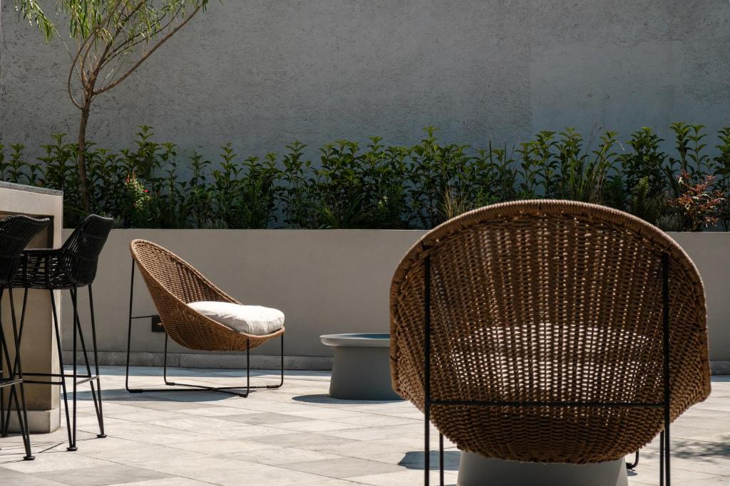 a group of chairs and tables in a patio at Casa Cibeles by Lumina in Mexico City