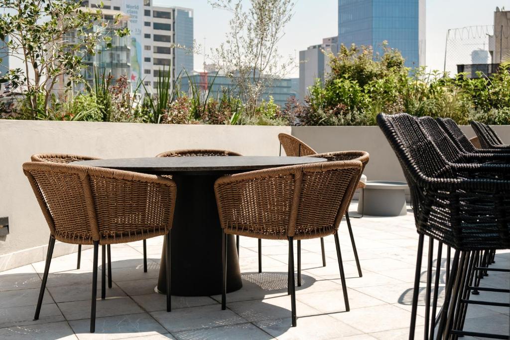 a black table and chairs on a patio at Casa Cibeles by Lumina in Mexico City