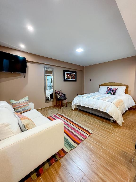 a bedroom with a bed and a couch at Huallata Hotel Boutique in Huaraz
