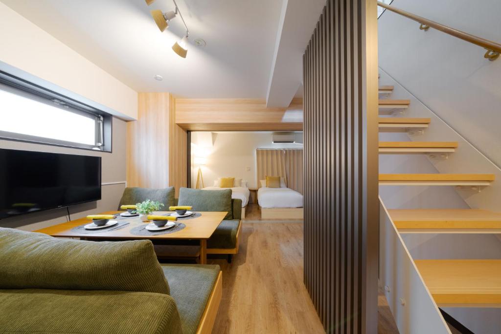 a living room with a couch and a table at TAKUTO STAY SAKAISUJI-HOMMACHI in Osaka