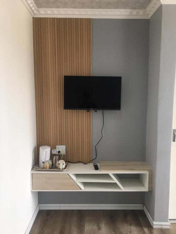 una mensola con un televisore appeso a un muro di Mavi Guest house a East London