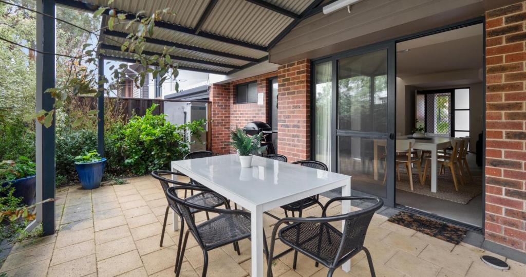 an outdoor patio with a white table and chairs at Forest Edge Villa - Family Friendly - Walk To Town in Margaret River Town