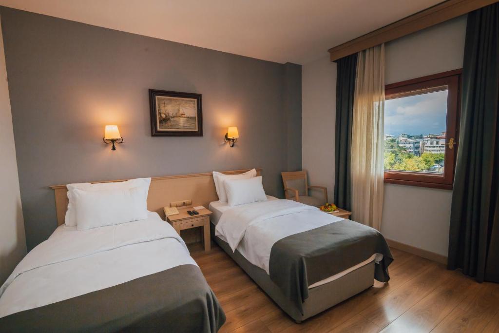 een hotelkamer met twee bedden en een raam bij Usta Park Hotel in Trabzon