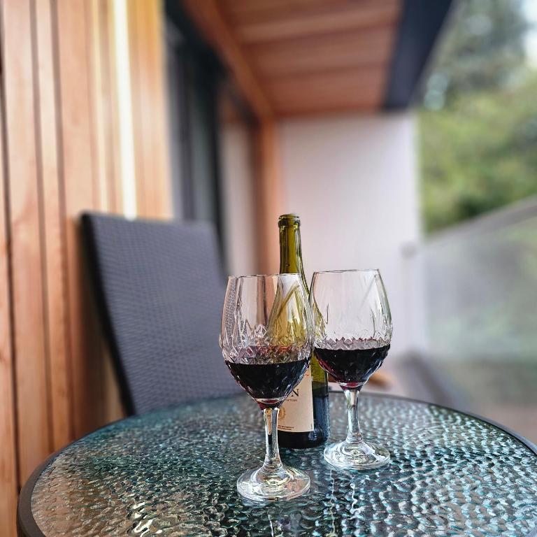 two glasses of red wine sitting on a table at Trinity- New Modern Apartment with FREE on road parking in Cambridge