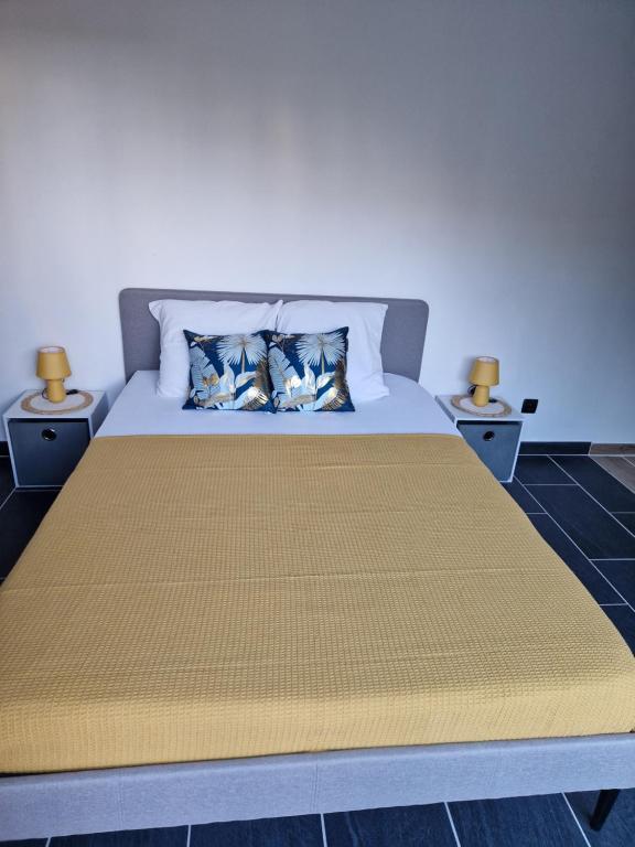 サン・タマン・モンロンにあるgrand Studio 2 personnesの寝室に枕が2つ置かれたベッド