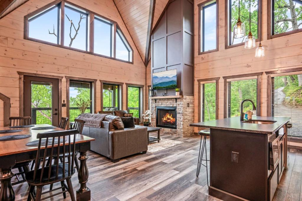 eine Küche und ein Wohnzimmer mit einem Kamin in der Unterkunft Smoky Bear Vista Brand New Luxury Cabin One Mile from Downtown Gatlinburg in Gatlinburg