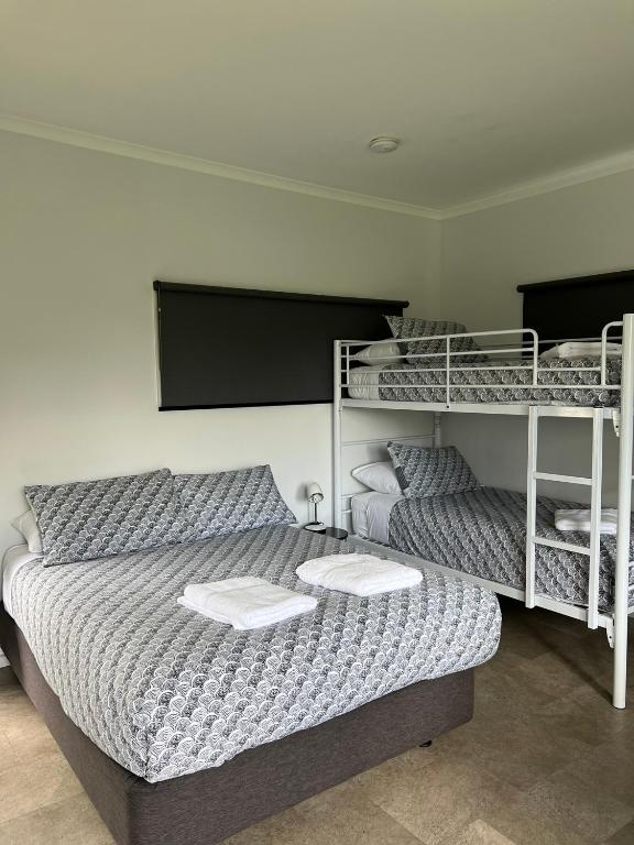 a bedroom with a bed and two bunk beds at Buchan Motel in Buchan