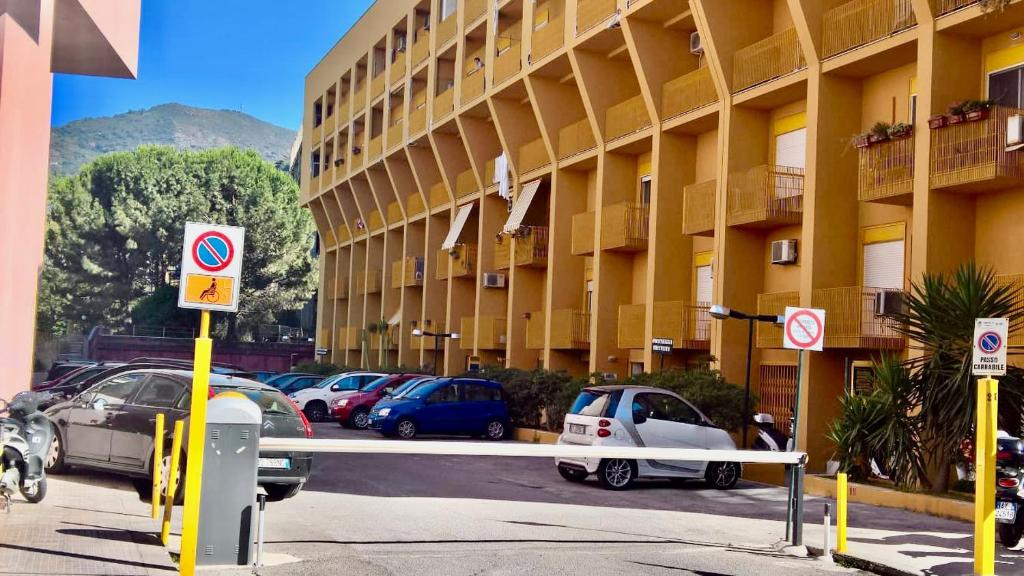 un parcheggio con auto parcheggiate di fronte a un edificio di YELLOW HOUSE a Cefalù
