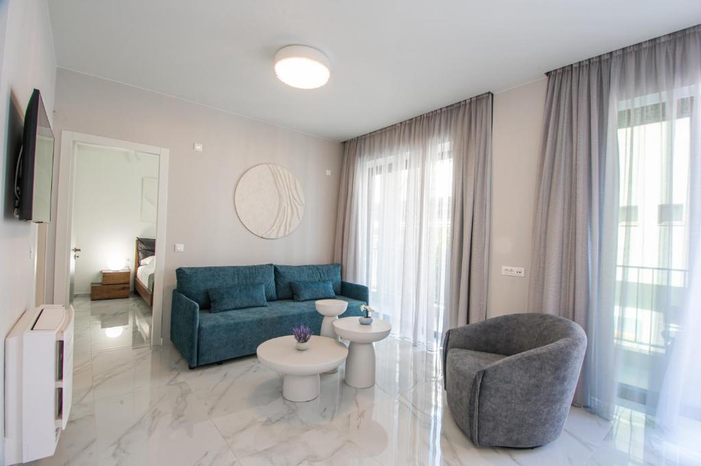a living room with a blue couch and a chair at Oikos luxury central apartment in Agios Nikolaos