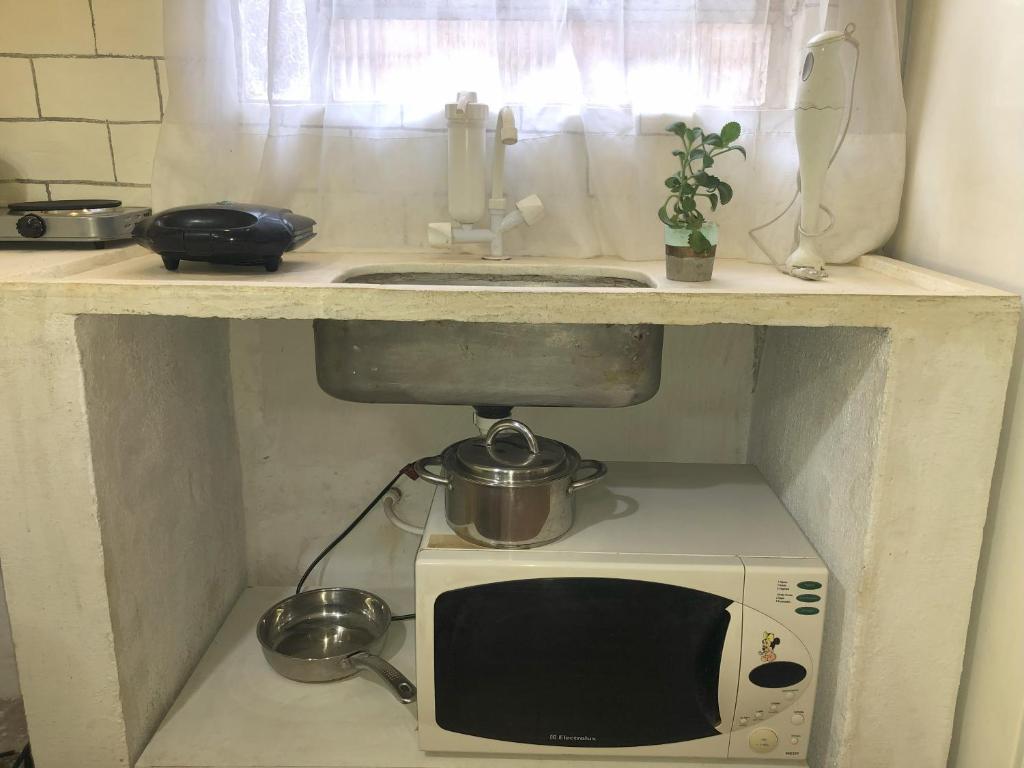 a microwave under a counter in a kitchen at Olinda Home in Olinda