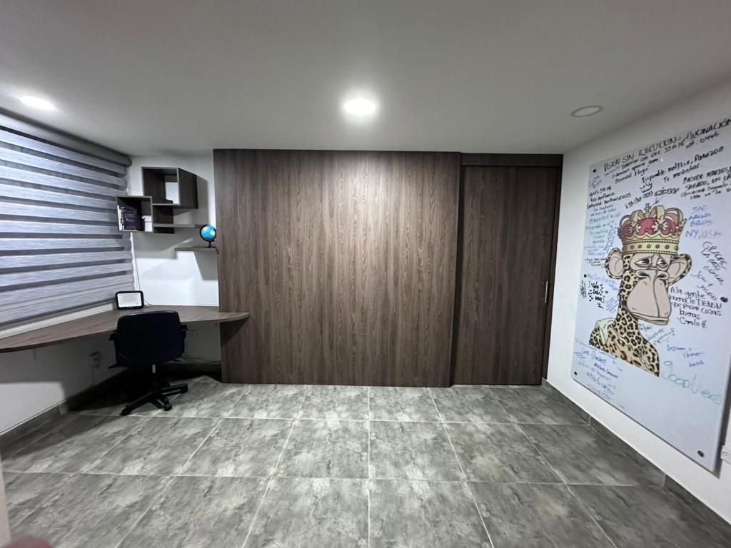 un bureau avec un bureau et un mur avec un dessin dans l'établissement Hermosa casa con hermosas amenidades y cuartos zona universitaria con luxxury amanecer con vista, à Lomas de Angelopolis