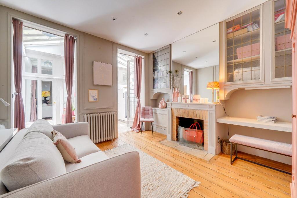 un salon avec un canapé et une cheminée dans l'établissement Le Départ Bordelais - Appt d'exception Hypercentre, à Bordeaux