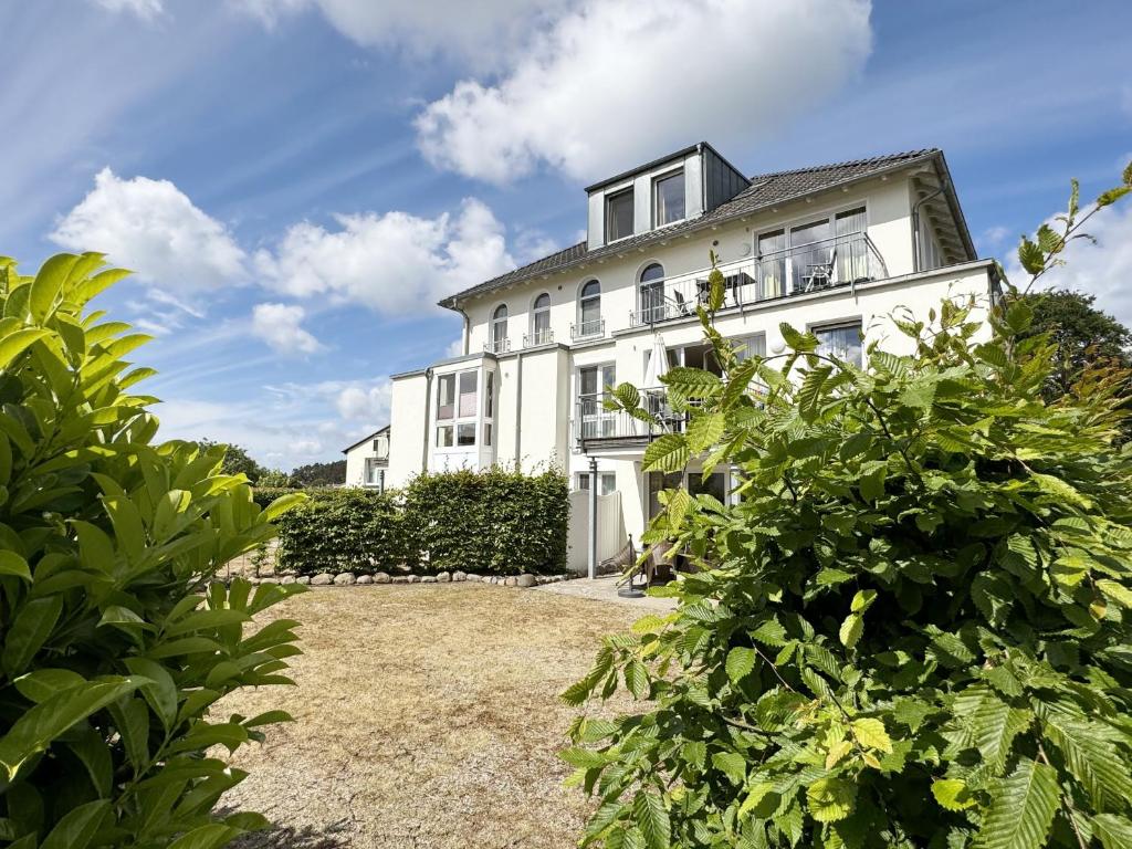una casa bianca con cespugli davanti di Haus Möwe II - Whg 01 mit Terrasse a Ostseebad Sellin