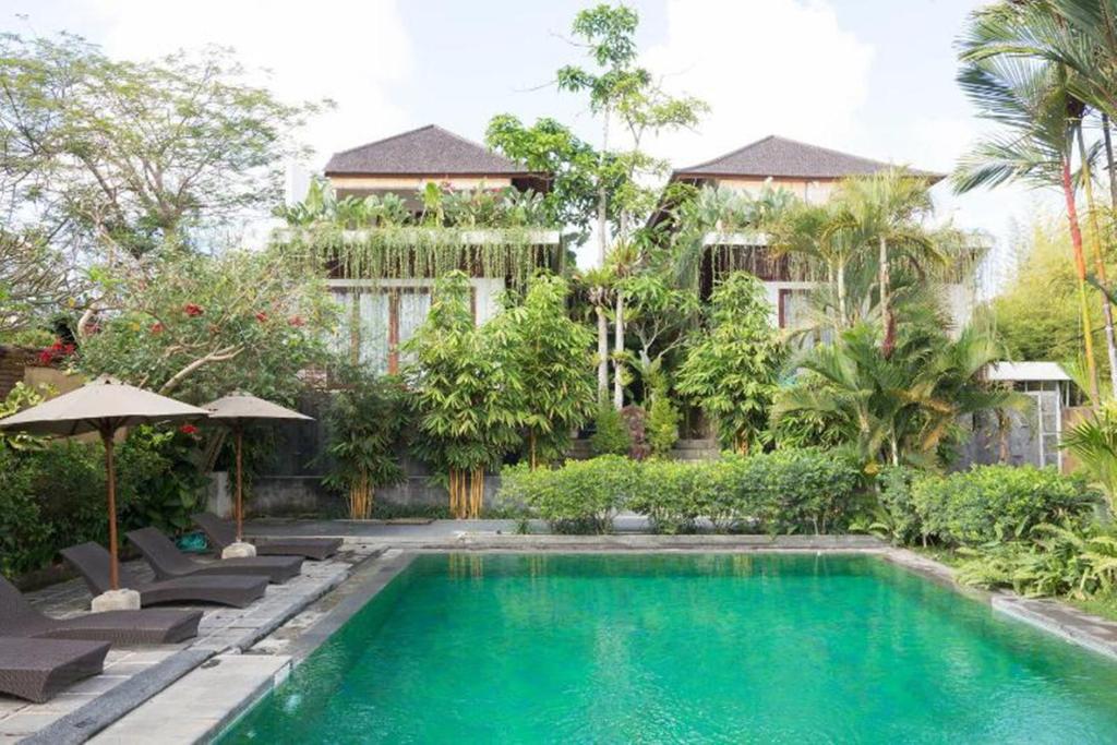 a swimming pool in front of a building at Aqua Bali Villa in Canggu