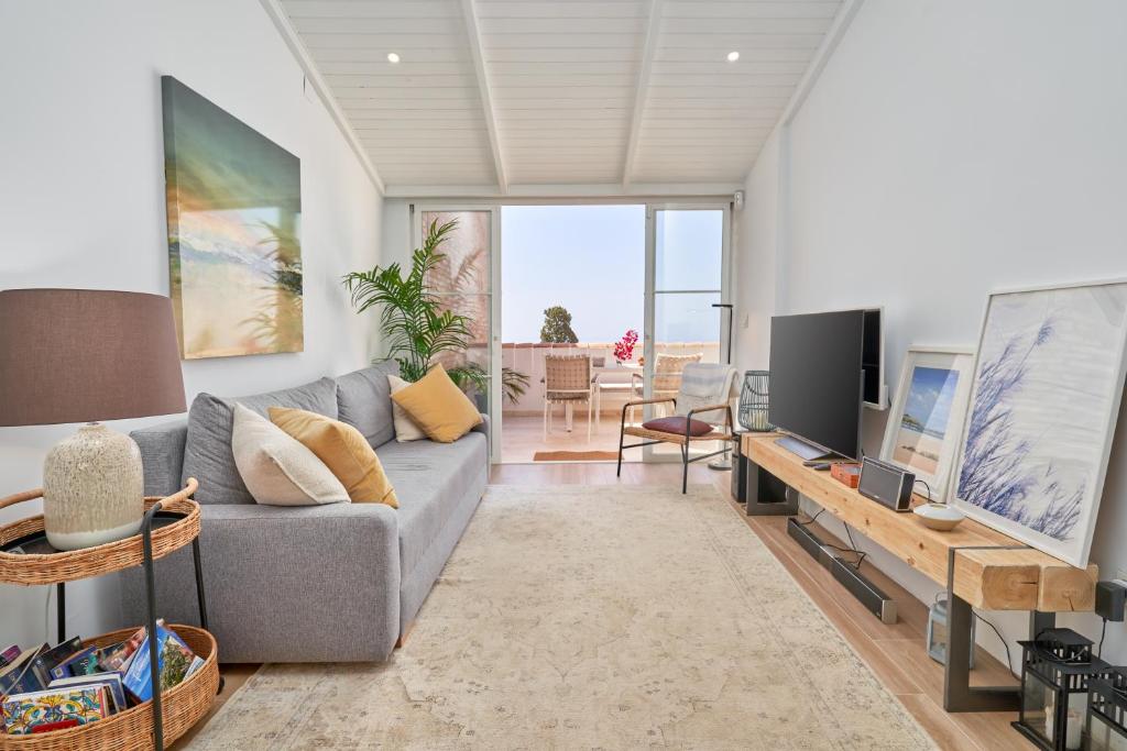 a living room with a couch and a tv at Apartamento Casita del Mar in La Herradura
