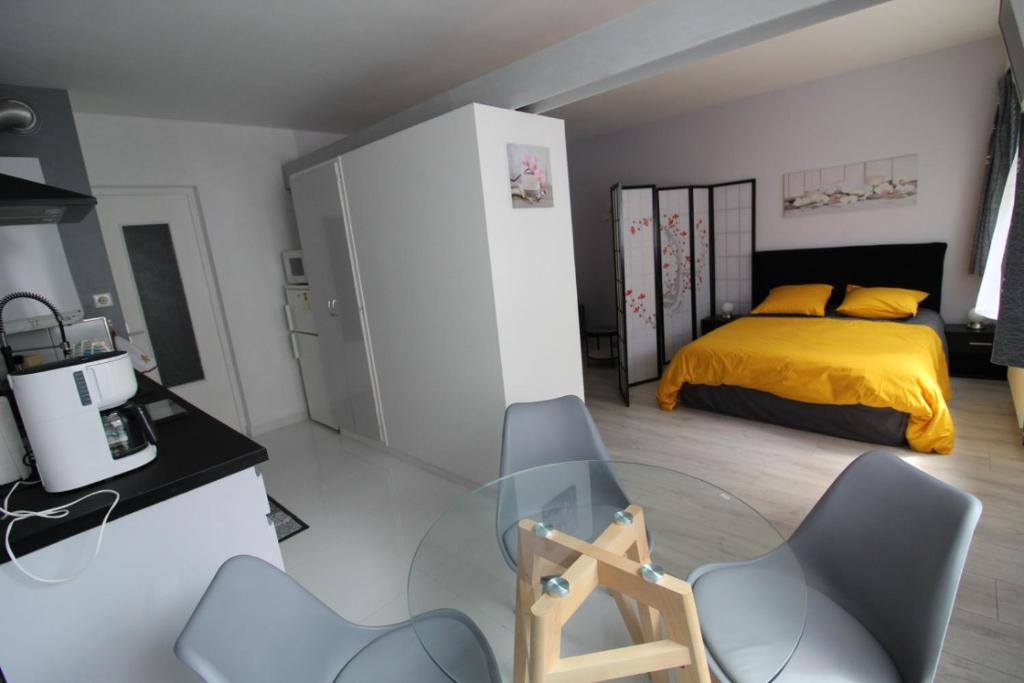 - une chambre avec un lit, une table en verre et des chaises dans l'établissement Studio Nancy Thermal Studio en petite résidence, à Nancy