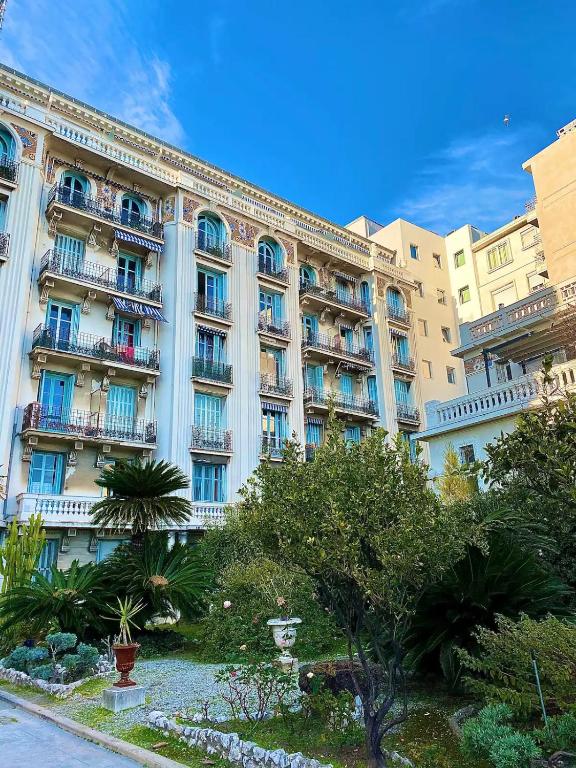un grand bâtiment avec un jardin en face dans l'établissement Sea La Vie, à Nice