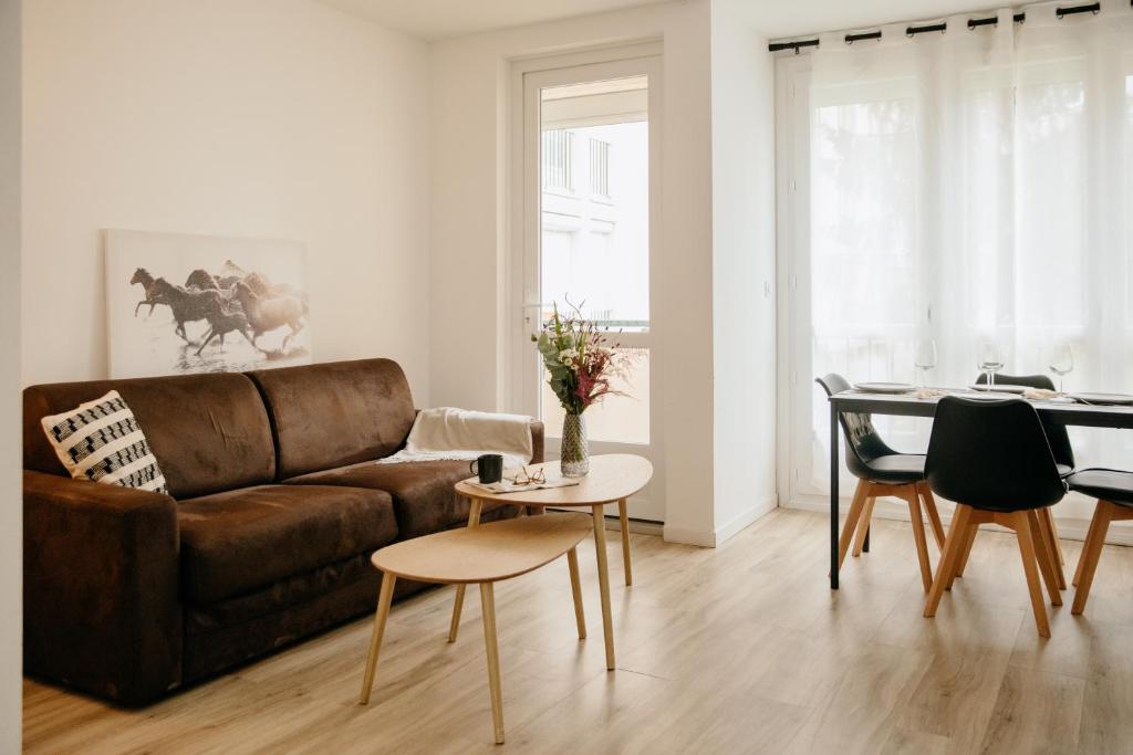 un salon avec un canapé marron et une table dans l'établissement L'escapade Rennaise en bord de vilaine, à Rennes