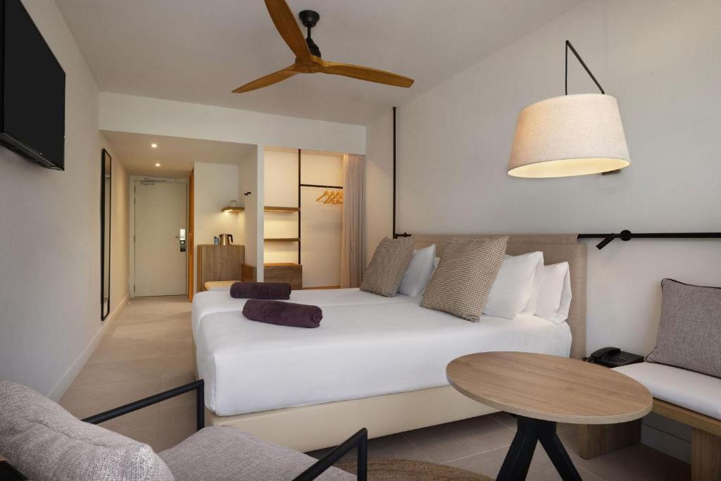 a bedroom with a white bed and a table at Inmood Aucanada 4 Sup in Port d'Alcudia