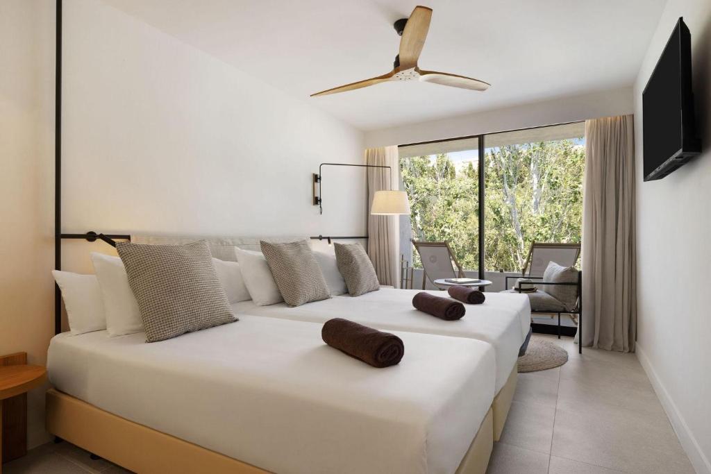 a bedroom with a large white bed and a living room at Inmood Aucanada 4 Sup in Port d'Alcudia