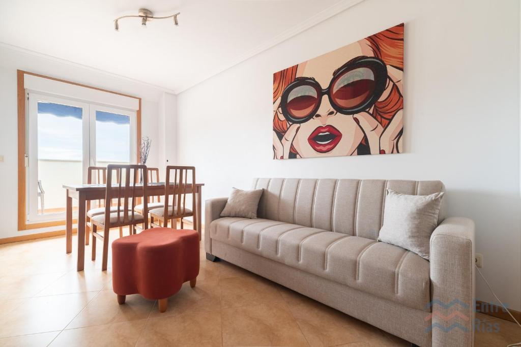 a living room with a couch and a painting at Fogar do Freixo - by entreRías in Cangas de Morrazo