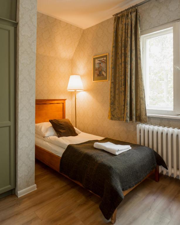 a bedroom with a bed and a window and a radiator at Villa Irena in Sopot
