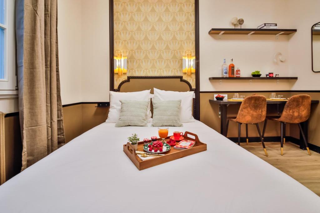- une chambre d'hôtel avec un lit et un plateau de nourriture dans l'établissement WS Opéra - Edimbourg, à Paris