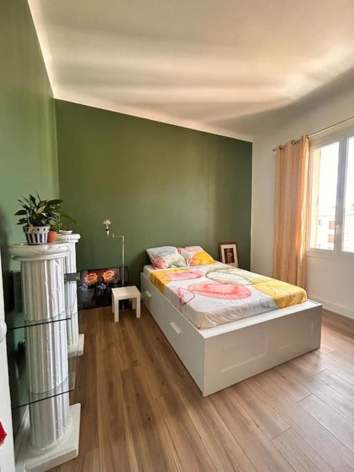 une chambre avec un lit et un mur végétal dans l'établissement Avignon - Appartement calme et climatisé, à Avignon