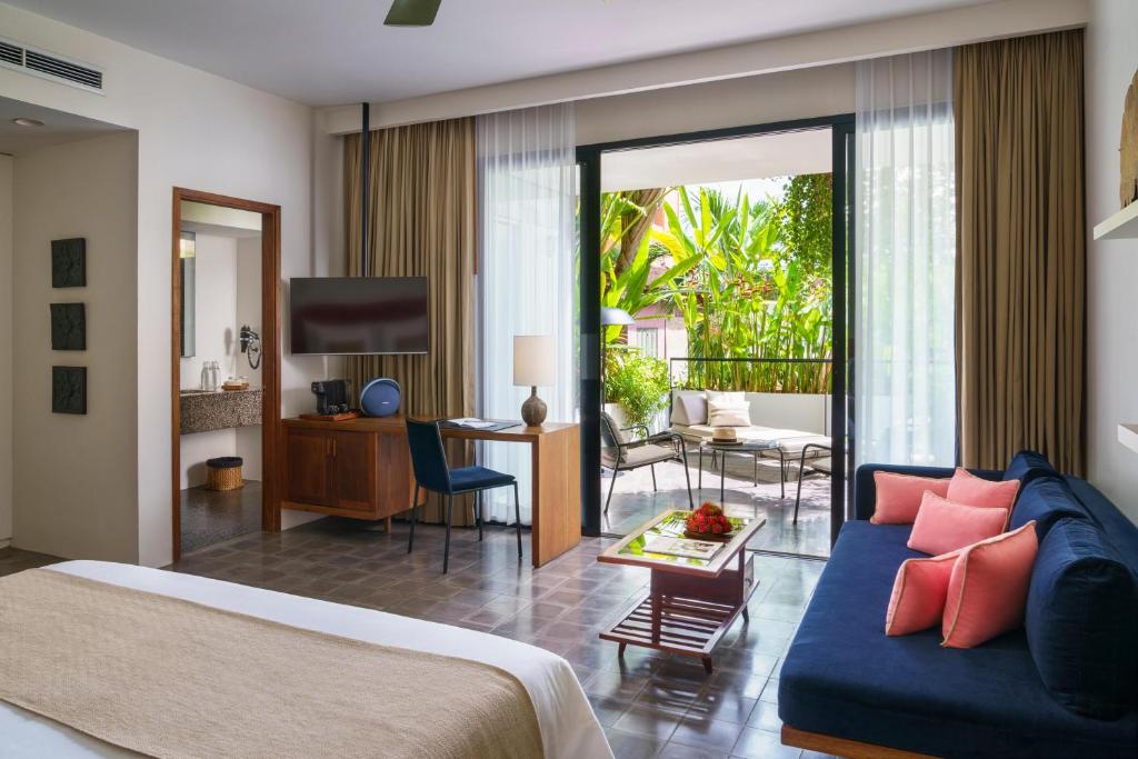 a bedroom with a bed and a living room at Viroth's Hotel in Siem Reap