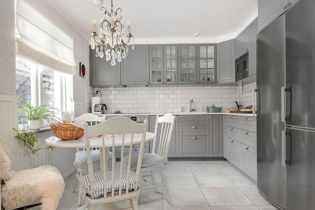 una cocina con una mesa y un refrigerador en Large 4 bedroom Villa with beautiful garden, en Visby