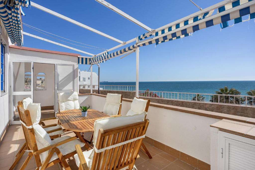 a balcony with a table and chairs and the ocean at La Terracita de Candi El Puerto in El Puerto de Santa María