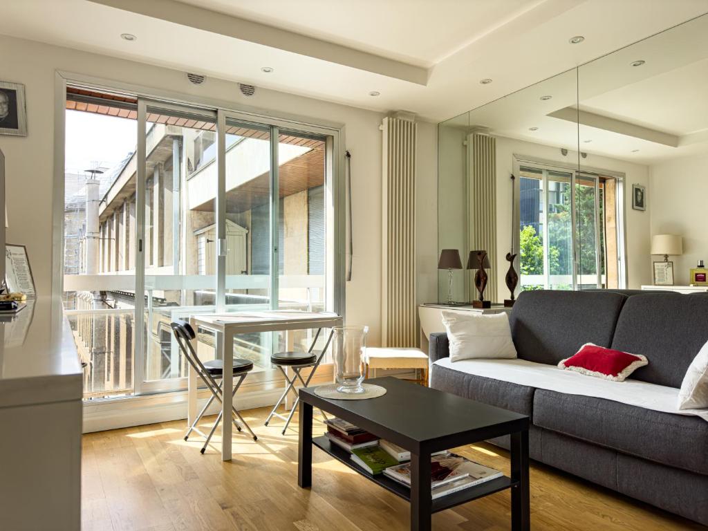 un salon avec un canapé et une table dans l'établissement PenBed -1BR - Proche Champs Elysées, à Paris