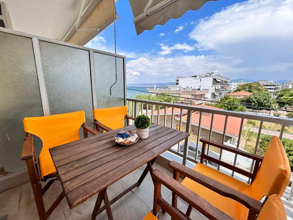 a balcony with a wooden table and chairs and the ocean at Sea Pleasure View Apartment in Perea