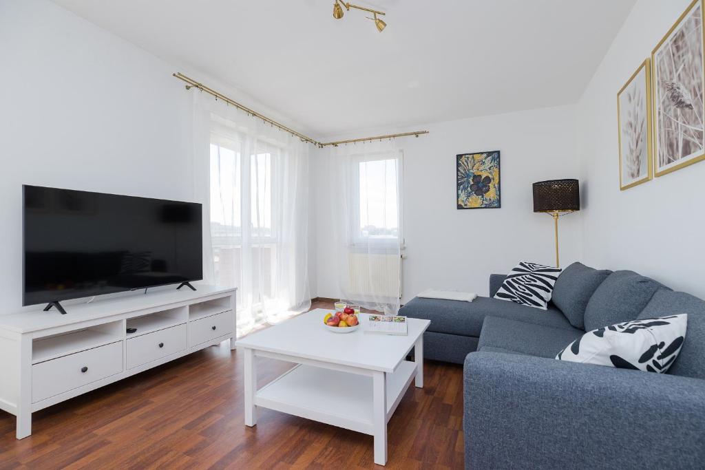 a living room with a blue couch and a tv at ShortStayPoland Tomcia Palucha B118 in Warsaw
