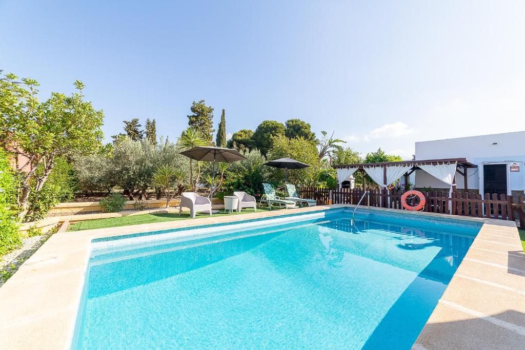 a swimming pool with blue water in a yard at Cortijo Indalo in Pechina