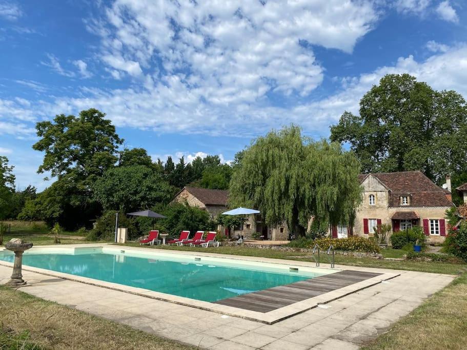 a swimming pool in front of a house at Vakantiehuis La Poire, op landgoed aan de Dordogne in Prudhomat