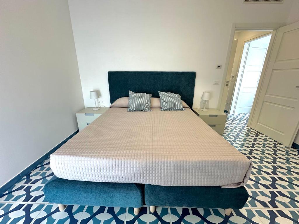 a bedroom with a large bed with a blue headboard at Blumare Amalfi Coast in Maiori